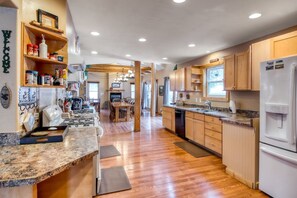 A spacious kitchen with wooden cabinets, granite countertops, and a built-in oven.