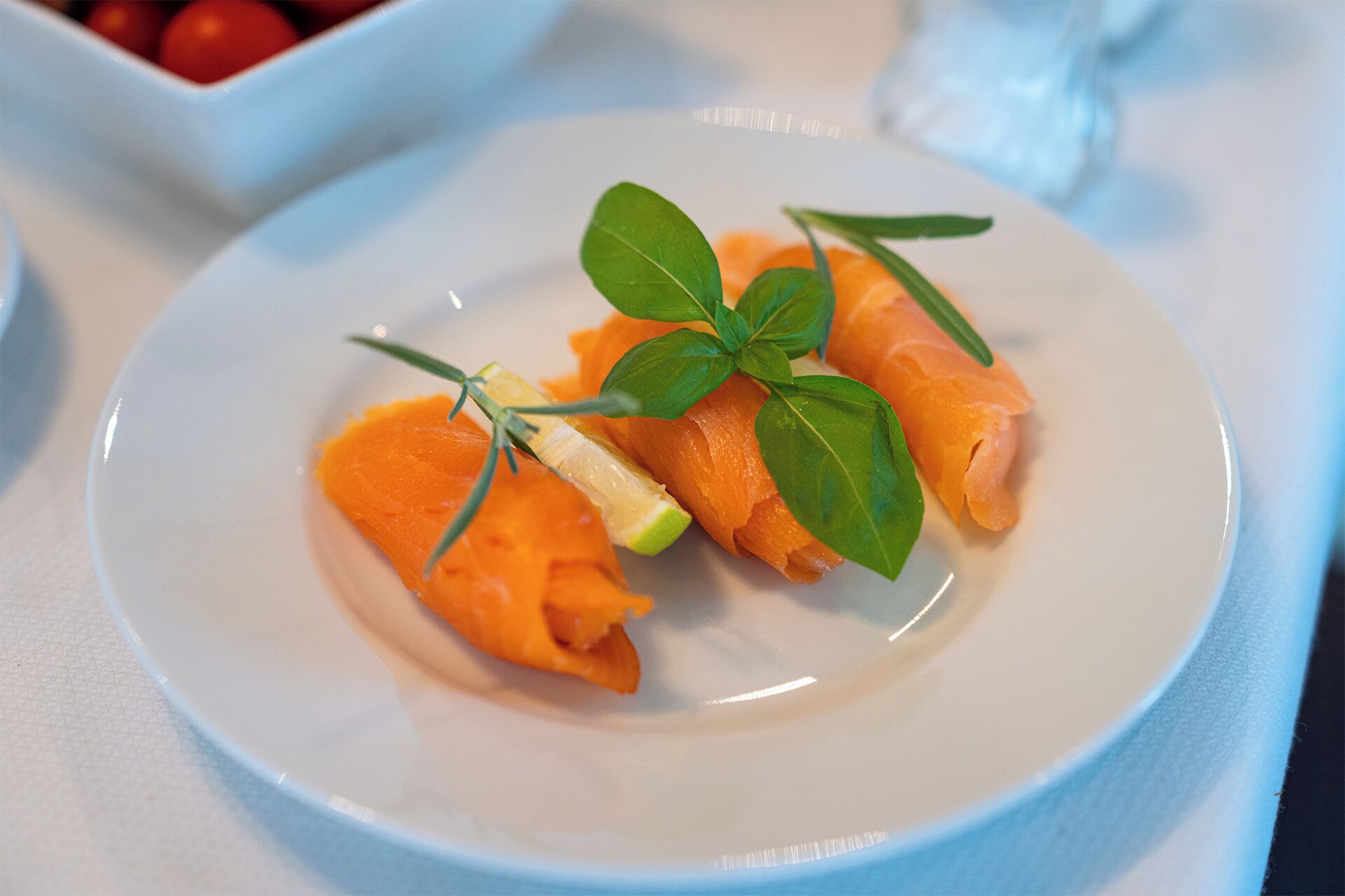 Een bord met zalm, gegarneerd met basilicum en rozemarijn.