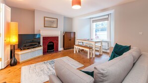Un salon avec une cheminée, un canapé, un téléviseur et un coin repas.