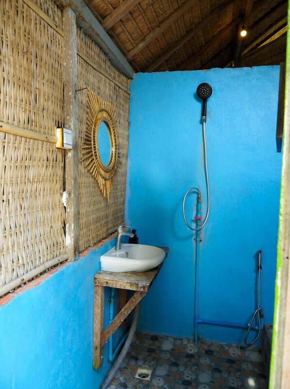 A bathroom with a blue wall, a white sink, a shower, and a woven wall decoration. - Kactus Your Island Sanctuary In Cambodia (Prey Nob)