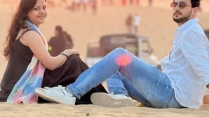 Two people sitting on the sand with a sunset in the background. - Hotel Robin Jaisalmer (Jaisalmer)