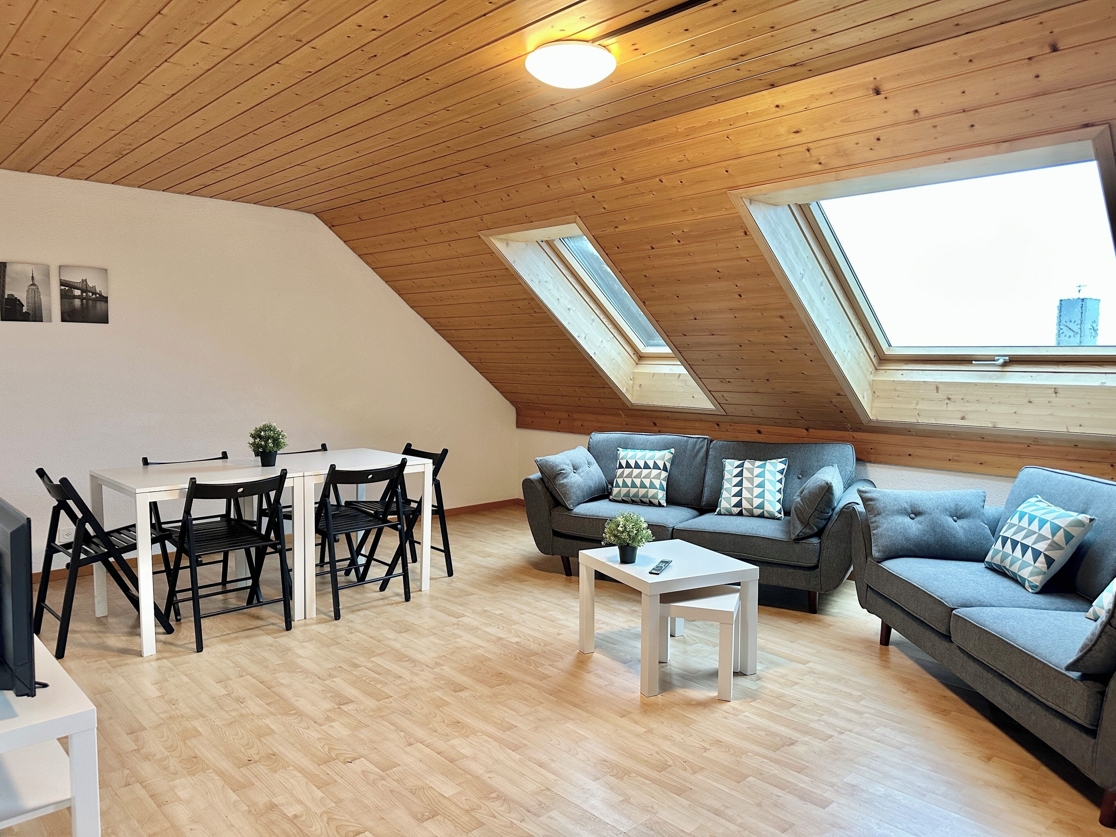 Ein gemütliches Loft-Zimmer mit Essbereich, einer Couch und einem kleinen Tisch.