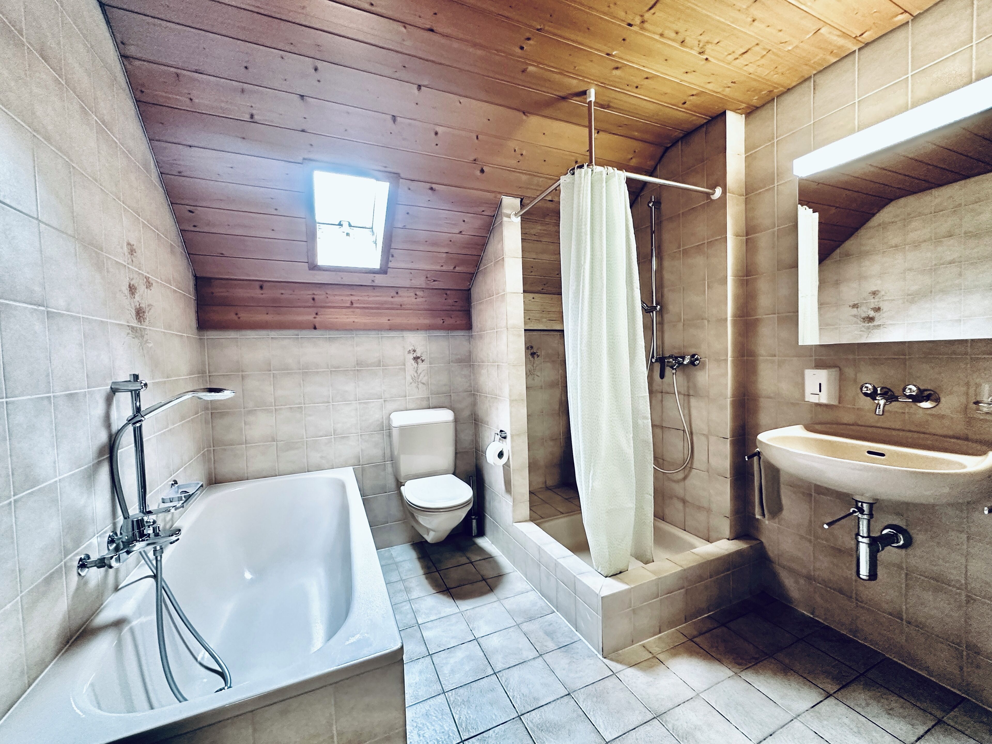 Une salle de bain équipée d’une baignoire, de toilettes, d’une douche et d’un lavabo.