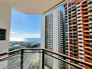 A high-rise building with balconies, a clear view of the sea, and a cityscape in the background. - Luxurious Haven in the Sky (Pasay)