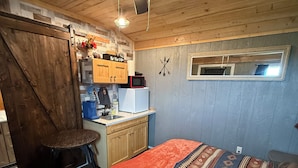 Una habitación acogedora con una cama, un escritorio y un ventilador de techo.