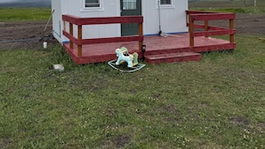 Un pequeño edificio de una sola planta, con puerta verde y ventanas, un porche rojo y un letrero que dice "COWGIRL".