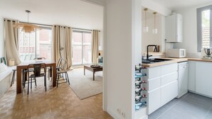 A modern kitchen with white cabinets, a wooden countertop, and a built-in wine cooler.