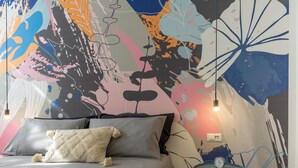 A bedroom with a bed, pillows, a small round table with a clock, and a wall mural. - 7Studios - 6 Purple (Milano)