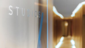 A blurred interior view with the word "STUDIOS" visible on a glass surface. - 7Studios - 6 Purple (Milano)