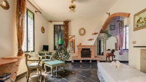 Una habitación con chimenea, cama, mesa de comedor y una silla.