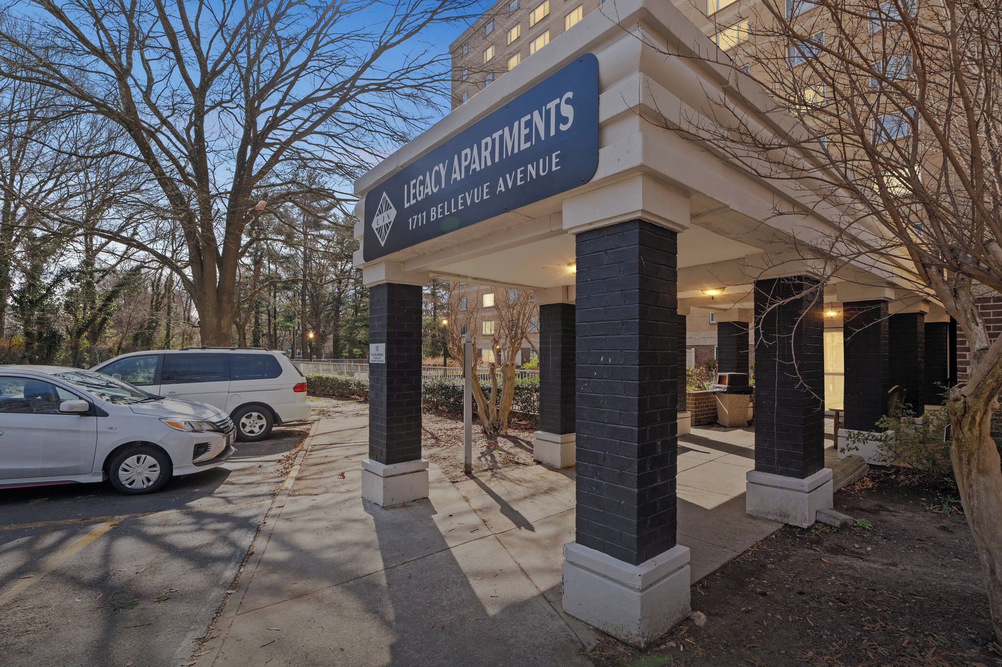Entrada de un edificio con un letrero que dice 'Legacy Apartments 1711 Bellevue Avenue'.