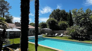 Een seizoensgebonden buitenzwembad en parasols bij het zwembad