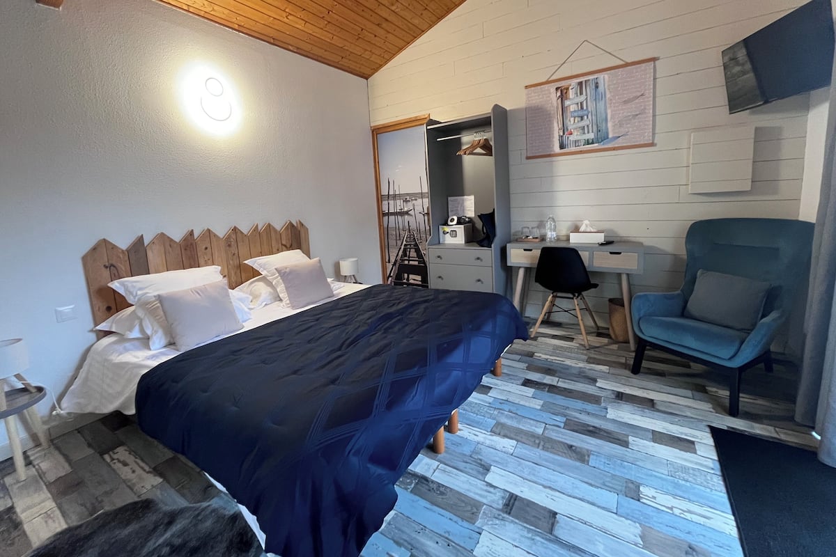 Une chambre à coucher avec un lit, un bureau, une chaise et un téléviseur.