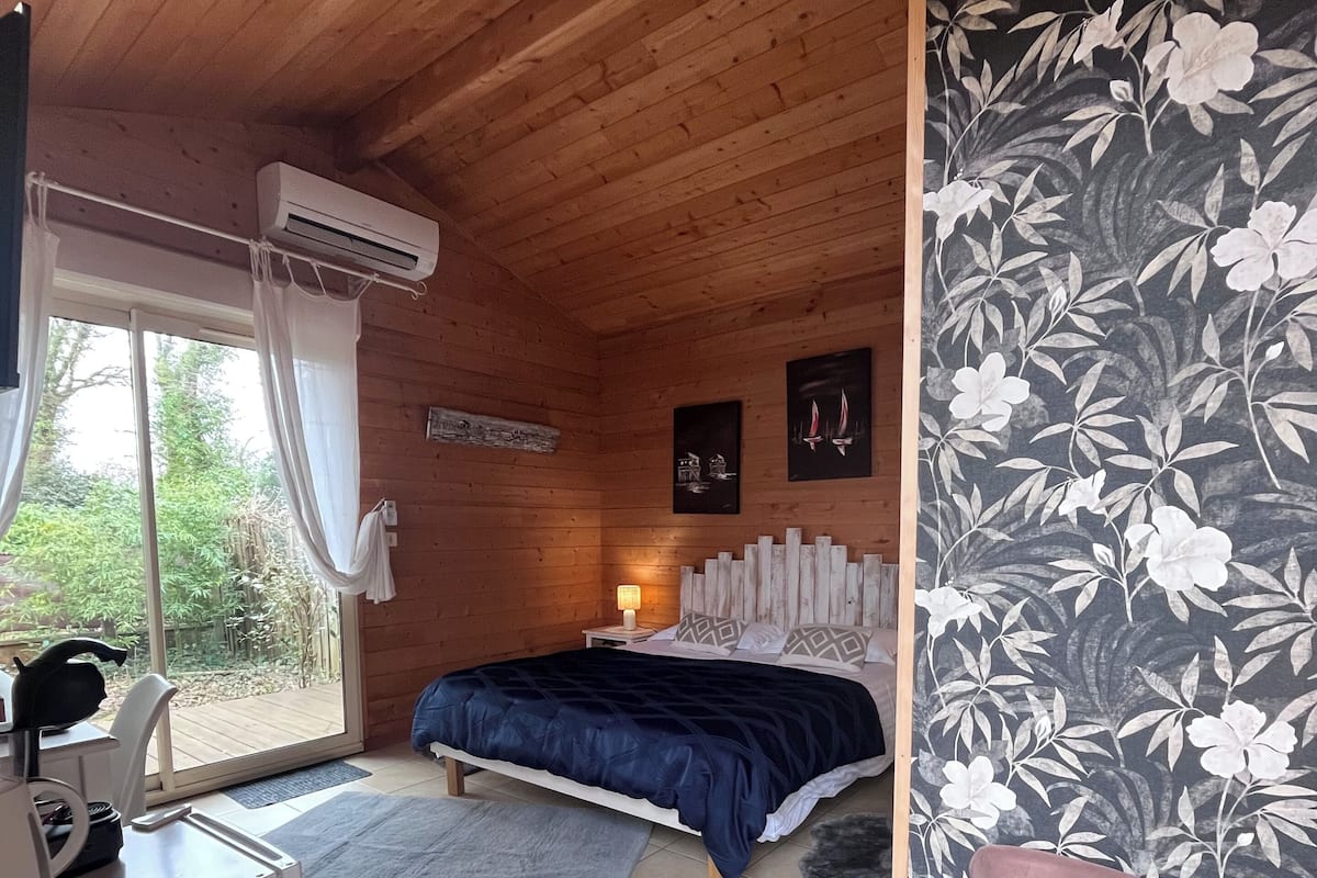Une chambre dans une cabane en bois, avec un lit, un bureau et une chaise.