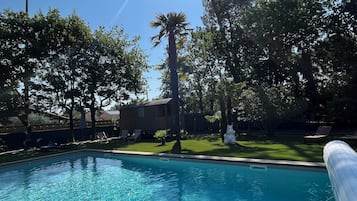 Een seizoensgebonden buitenzwembad en parasols bij het zwembad