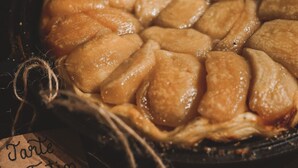 A close-up of a baked dish with a lattice crust, possibly a pie or tart, in a dark pan.