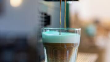 A close-up of a coffee machine dispensing coffee into a glass cup.