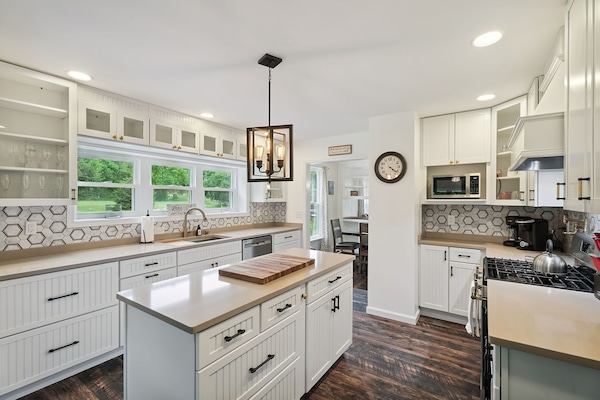 This bright, beautifully updated kitchen features plenty of counter space, open shelving, and scenic views to inspire every meal.