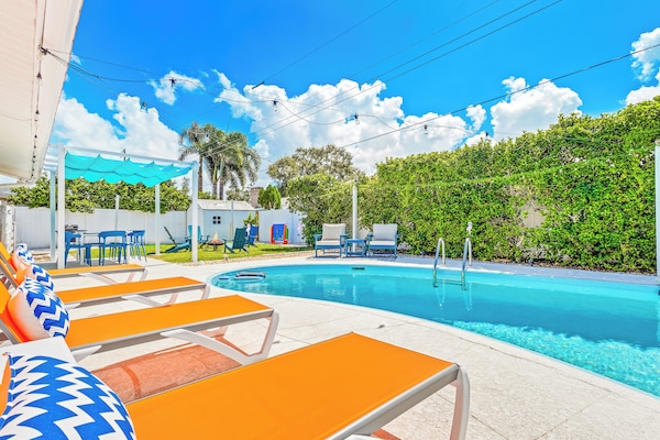 Welcome to your perfect beach getaway—this inviting backyard features a sparkling pool, spacious lounge areas, and lush greenery, creating the ideal spot to relax, soak up the sun, and start your vacation in style.