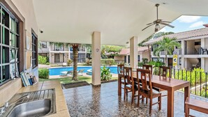 A covered outdoor area with a pool, dining table, and chairs. - Green Turtle 20 in Coco is an elegantly appointed 2-bedroom, 1-bath condo with a swimming pool located within a 7-minute walk of the beach. <br><br>📢Important announcement: Golf cart with condo available upon request for additional charges (Playas Del Coco)
