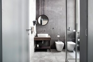 A modern bathroom with a large mirror, a sink, a bidet, and a toilet. - Superb Room for 4 near Duomo di Milano (Milan)