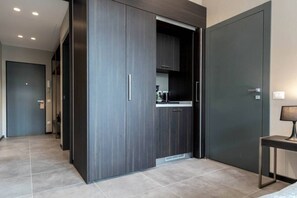 A modern kitchen with dark cabinetry, a built-in oven, and a countertop with a coffee machine. - Superb Room for 4 near Duomo di Milano (Milan)