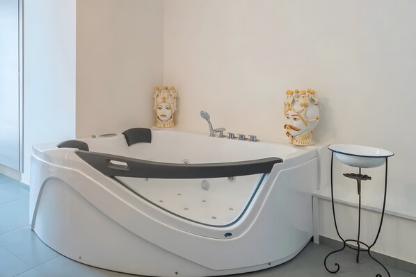 A modern bathroom with a freestanding bathtub, a small round table, and decorative wall art.