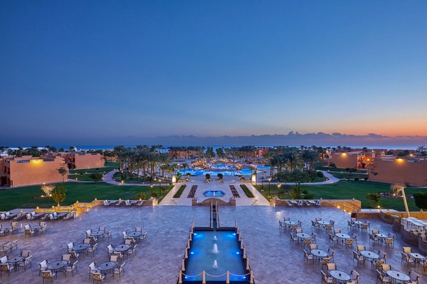 Unwind at dusk as lights shimmer across the courtyard pools.