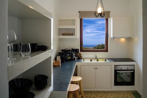 A compact kitchen with a window, a microwave, a sink, and a dishwasher. - Two Bedroom Villa with Sea View, Kaminia Holiday Homes (Santorini)