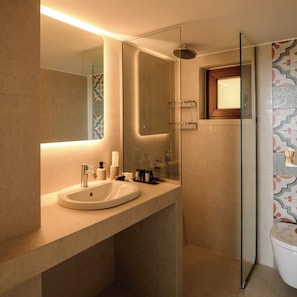 Un baño moderno con un espejo grande, un lavabo y una zona de ducha.