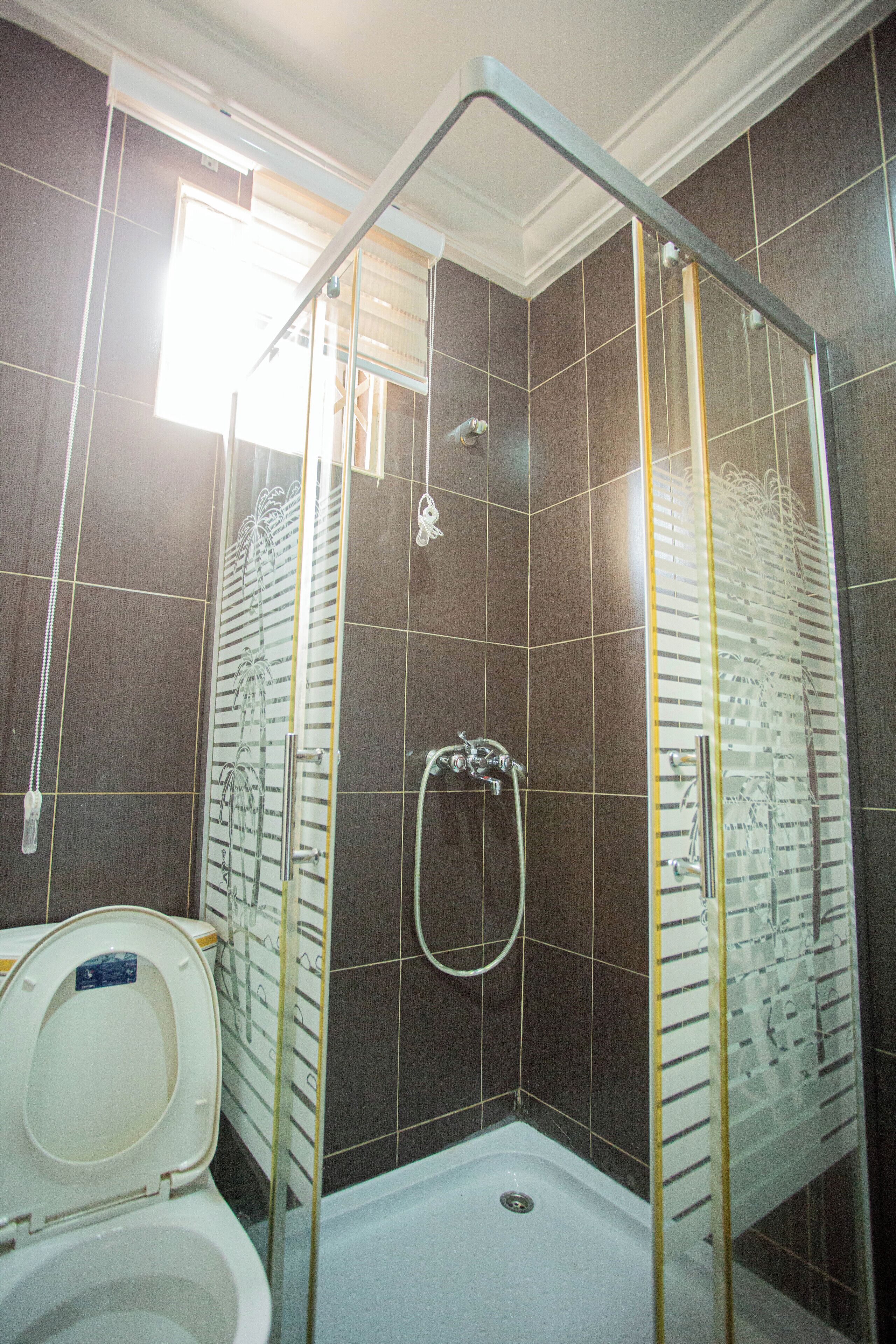 A shower with a glass door, a bathtub, and a toilet.