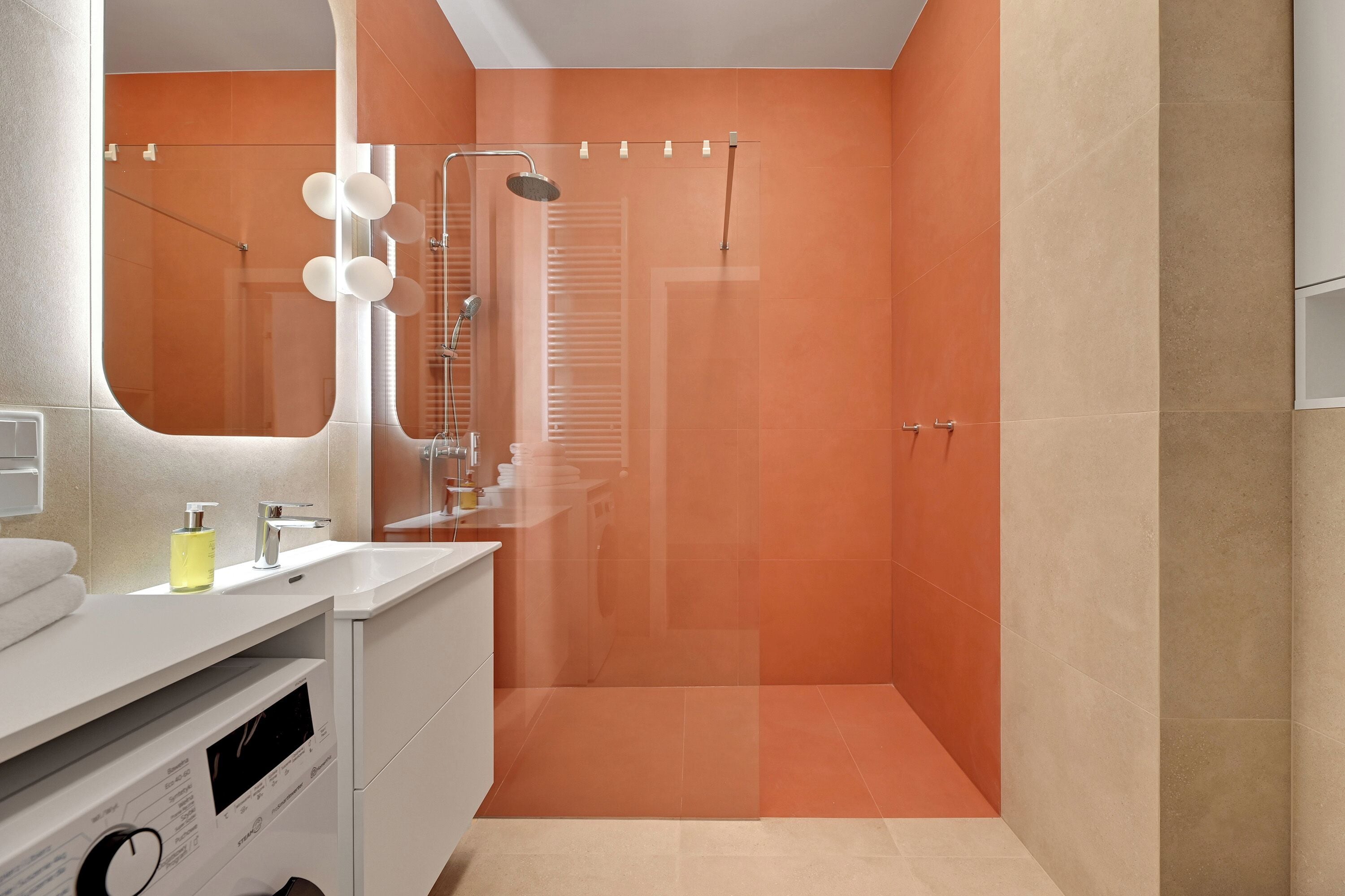 A modern bathroom with a shower, a vanity with a mirror, and a toilet.