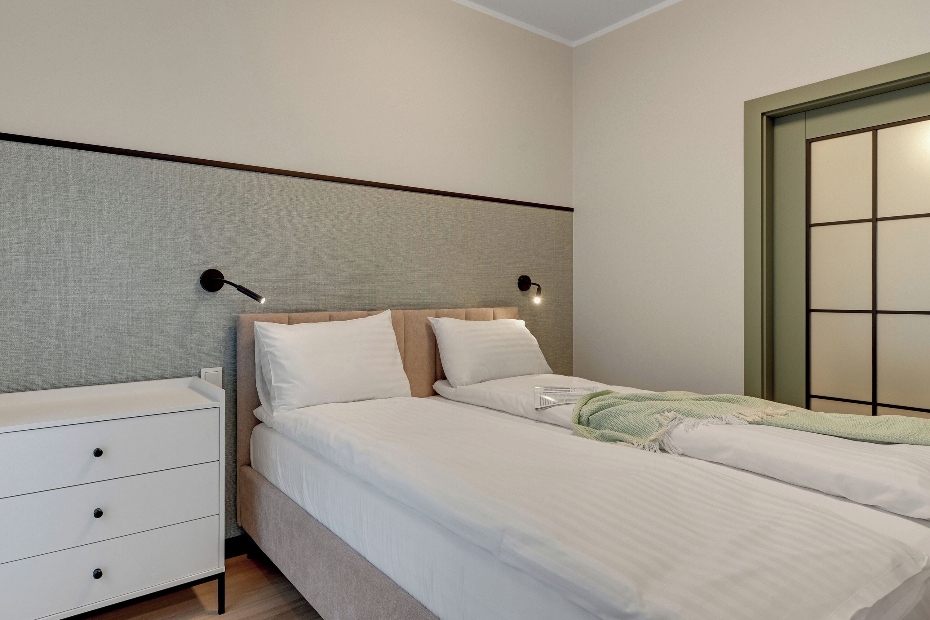 A bedroom with a bed, bedside tables, and a nightstand.