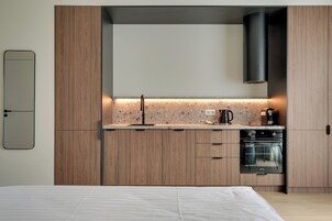 A modern kitchen with wooden cabinets, a built-in oven, and a countertop with a backsplash.
