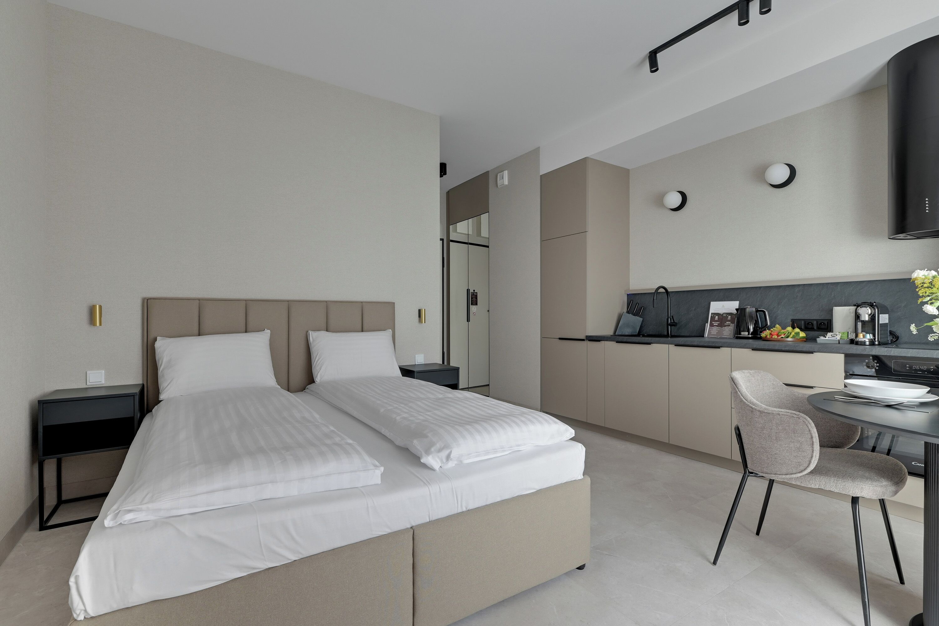 Une chambre d’hôtel moderne équipée d’un grand lit, d’un bureau et d’une kitchenette.