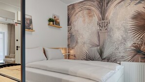 A bedroom with a bed, a desk, and a radiator. - GRANO APARTMENTS Gdańsk Granaria (Gdańsk)
