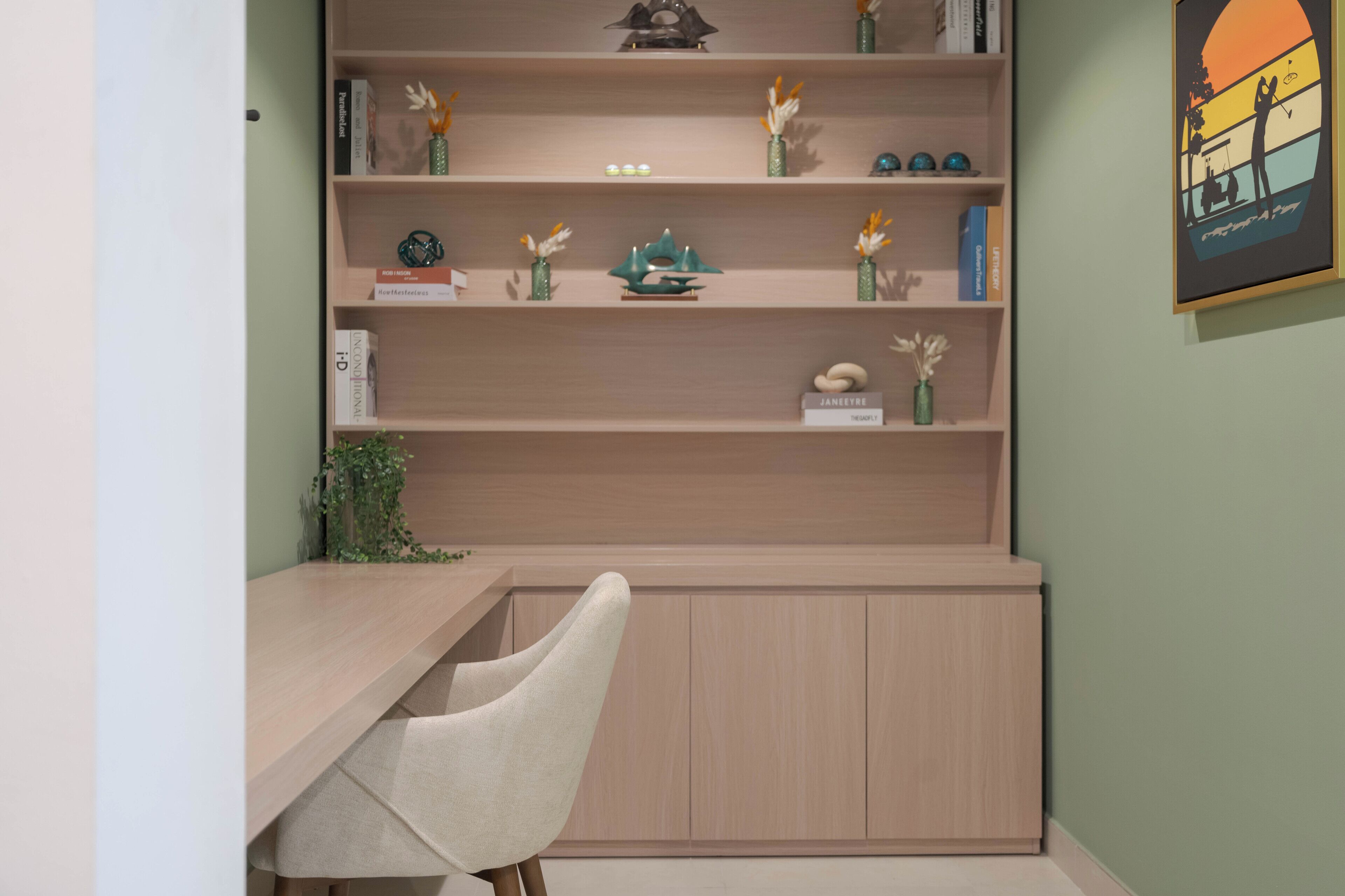 A modern room with a wooden desk, a chair, and a bookshelf with decorative items.