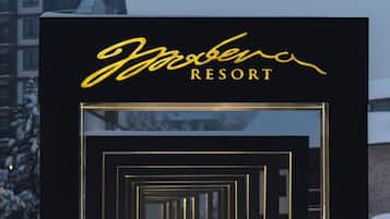 A snow-covered pathway leading to a building with a sign that reads "Yazbeka RESORT".