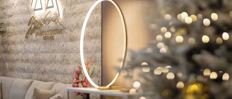 A modern interior with a stone wall, a sofa, and a Christmas tree with lights.