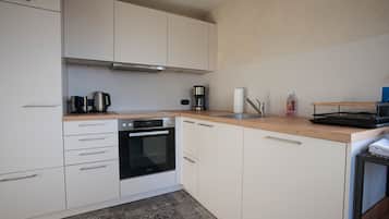 Een koelkast, een oven, een kookplaat, een vaatwasser