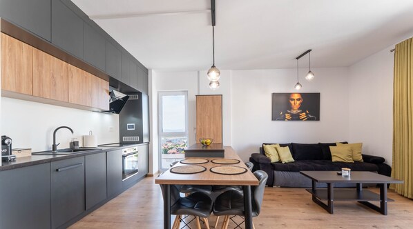 A modern apartment with a kitchen, dining area, and living room. - MoHost Properties (Brașov)