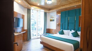 Une chambre à coucher aux murs lambrissés, avec un lit, un téléviseur et une vue sur l’extérieur.