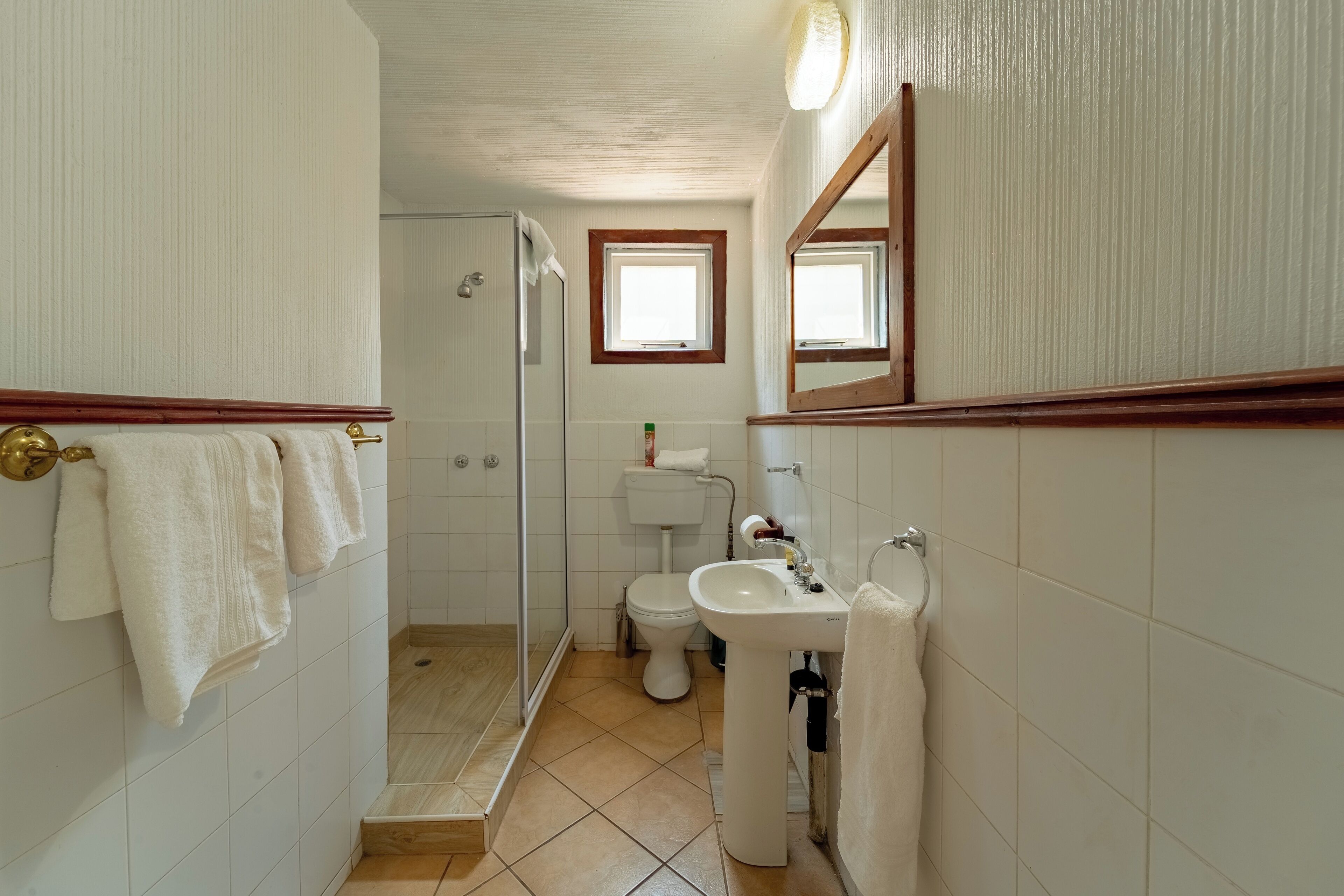 Une salle de bain avec une douche, des toilettes, un lavabo et une fenêtre.