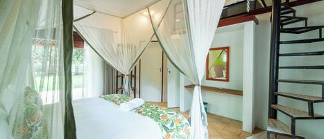 A room with a bed, a staircase, and a window with curtains.