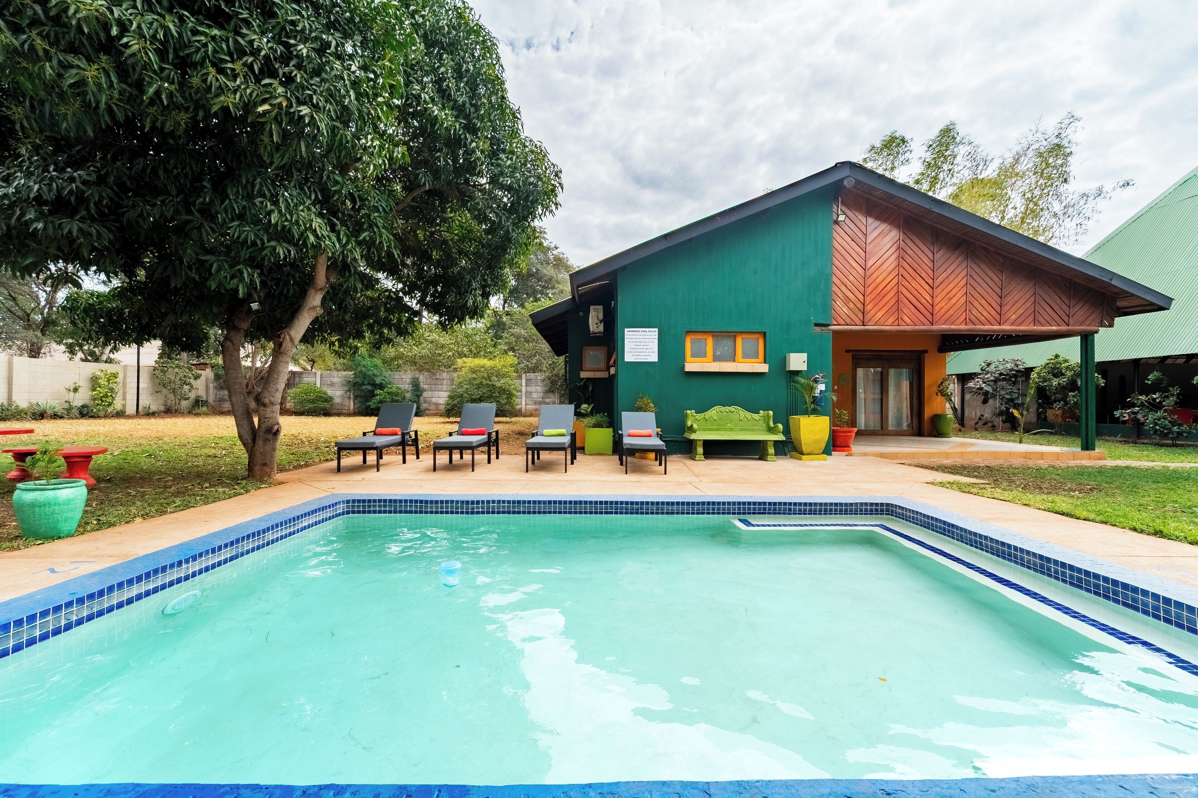A swimming pool with lounge chairs and a covered patio area.