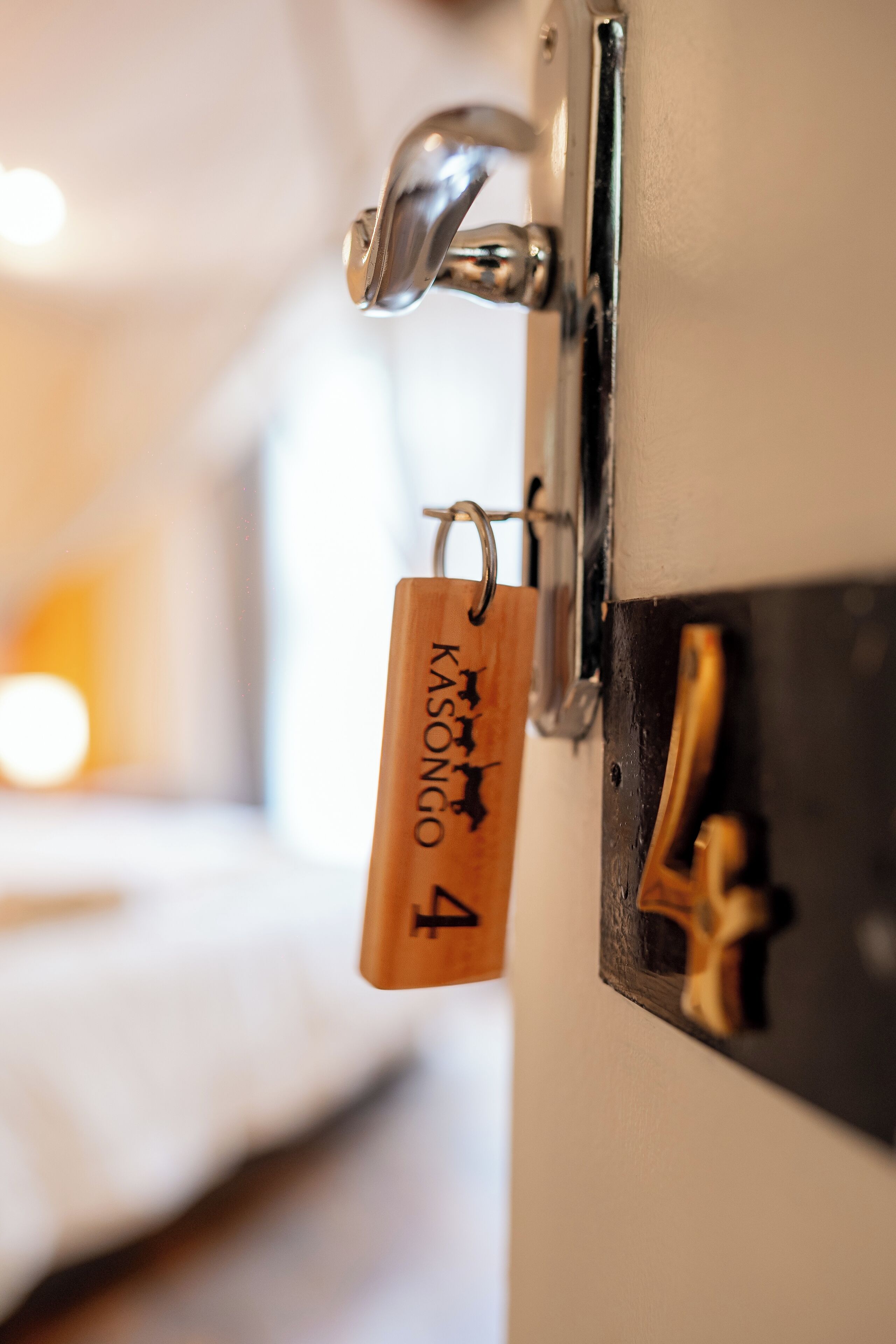 A hotel room door with a key card holder displaying a room number and a key.