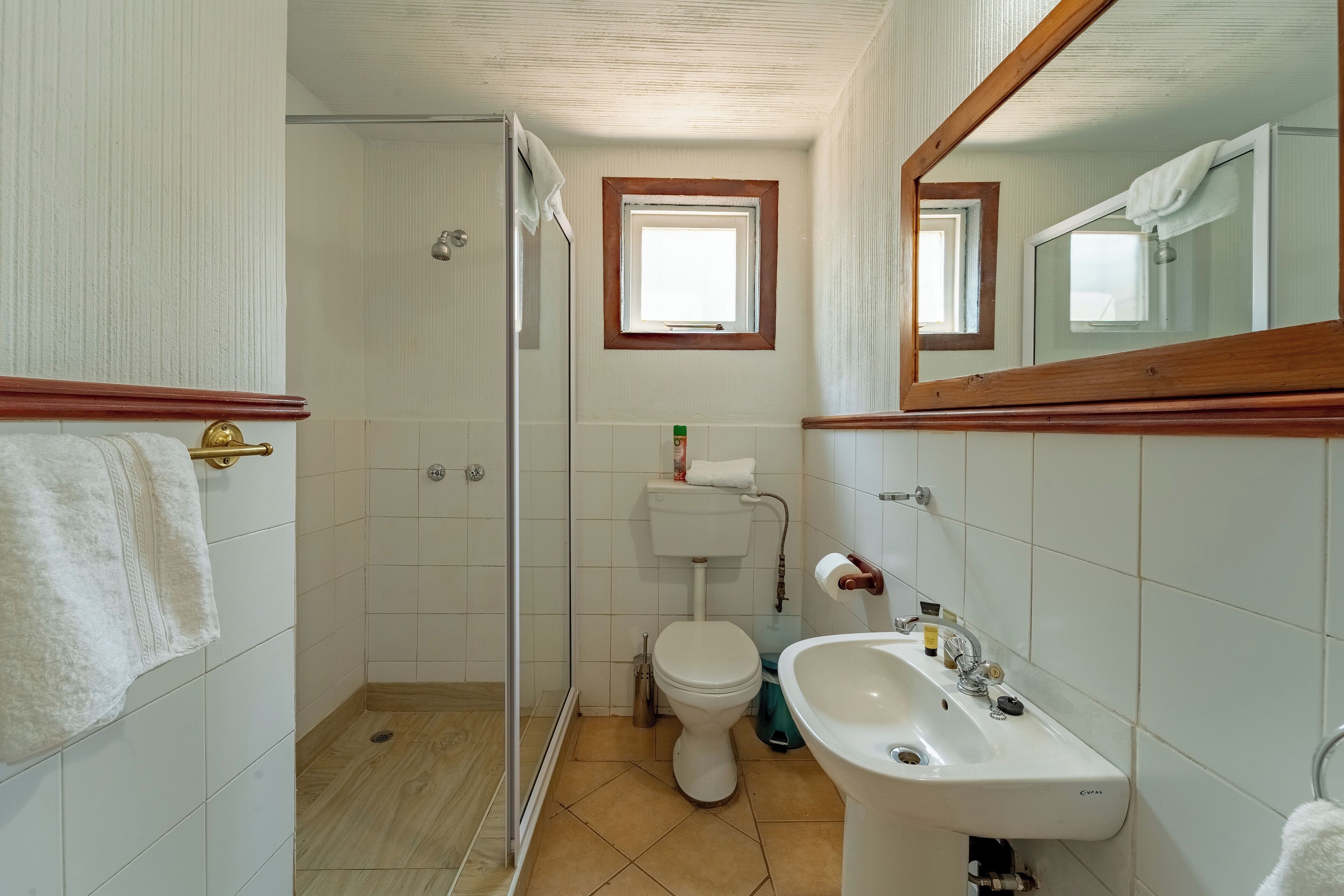 A bathroom with a toilet, sink, and shower area.