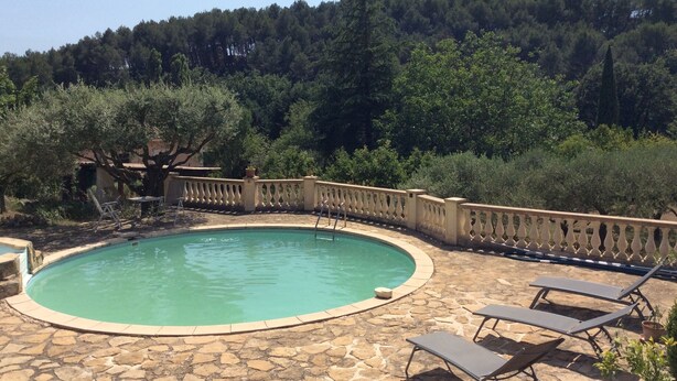A circular pool with a stone deck, surrounded by a balustrade and lounge chairs. - House in Provence, 15 minutes from the beach, 20 minutes from Aix and Marseille. (Auriol)