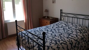 A bedroom with a bed, wooden dresser, and a nightstand. - House in Provence, 15 minutes from the beach, 20 minutes from Aix and Marseille. (Auriol)