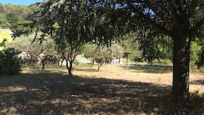 A park with trees, a playground, and a stone wall in the background. - House in Provence, 15 minutes from the beach, 20 minutes from Aix and Marseille. (Auriol)